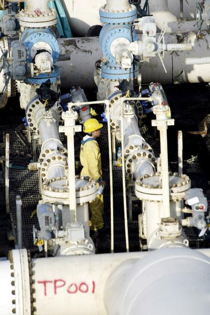 An iraqi techniqian inspects oil pipes at the al-Bakr port in the southern Iraqi city of Basra