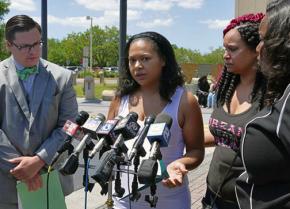 Laniya Miller's mother speaks to reporters, surrounded by family and supporters